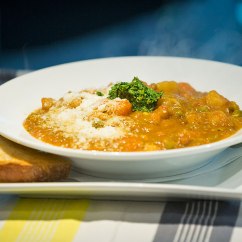 Minestrone Soup: traditional Italian thick vegetable soup served with pesto And a slice of sourdough bread