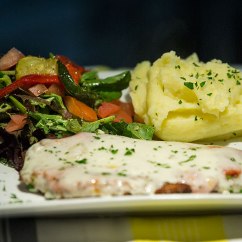 Parmigiana: chicken schnitzel topped with napoletana sauce and melted cheese. Served with mashed potato and salad