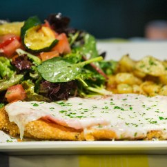 Pollo Alla Valdostana: chicken schnitzel topped with ham and melted cheese Served with roasted potato and salad